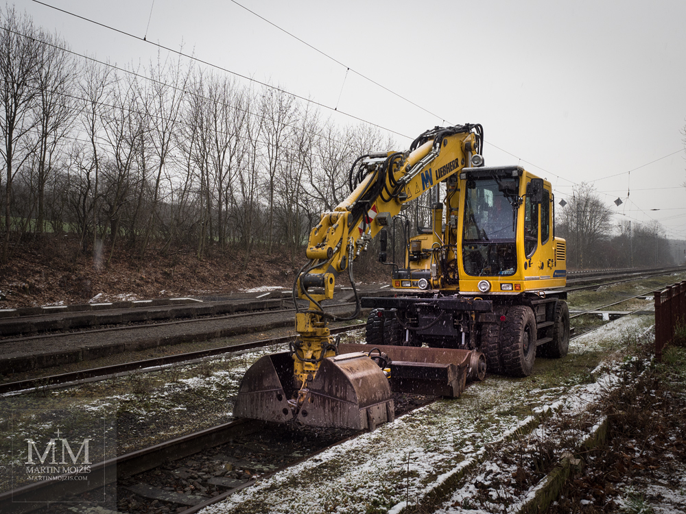A yellow excavator with an additional undercarriage, enabling driving and working in the railway yard. Photograph created with the Olympus 12 - 40 mm 2.8 Pro lens.